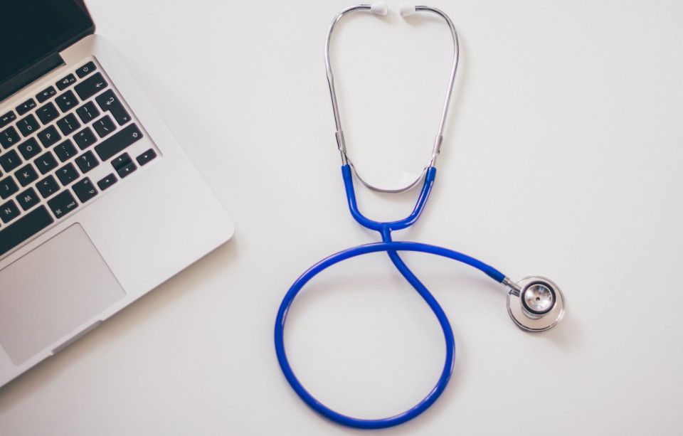 stethoscope next to a laptop