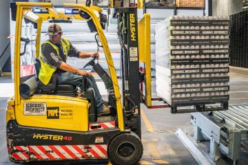 A forklift driver moves pallets